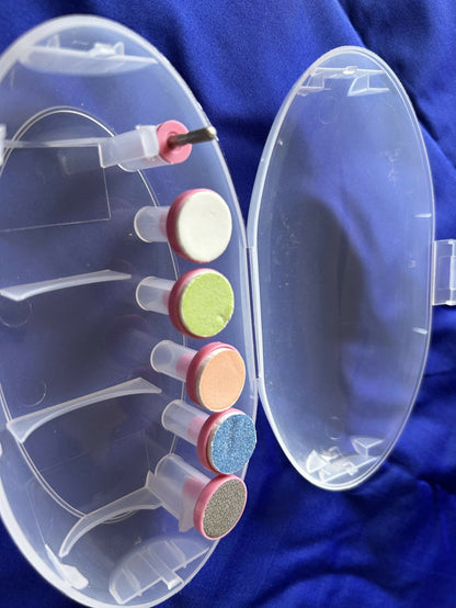 Clear nail drill with colored attachments on a blue background