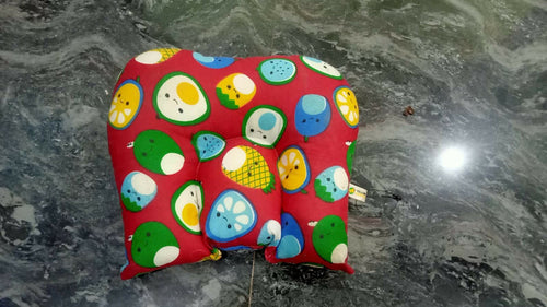 Colorful children's seat pad with animal patterns on a marble surface