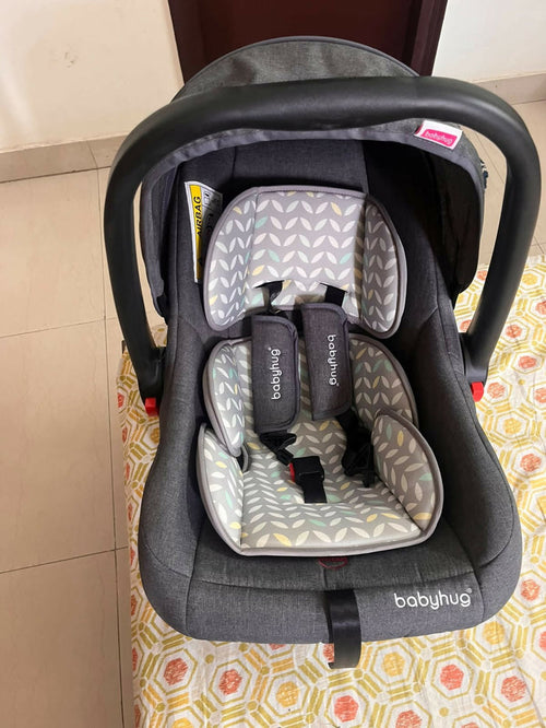 Babyhug Car Seat Cum Carry Cot with rocking base for newborns, rear-facing infant car seat featuring a 5-point safety harness, ergonomic carry handle, padded seat, and removable canopy for safe travel and comfortable carrying.