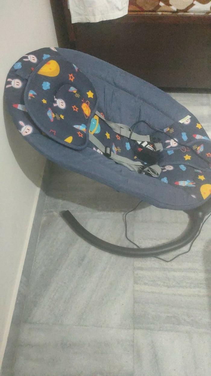 Baby swing with colorful patterns on a wooden floor