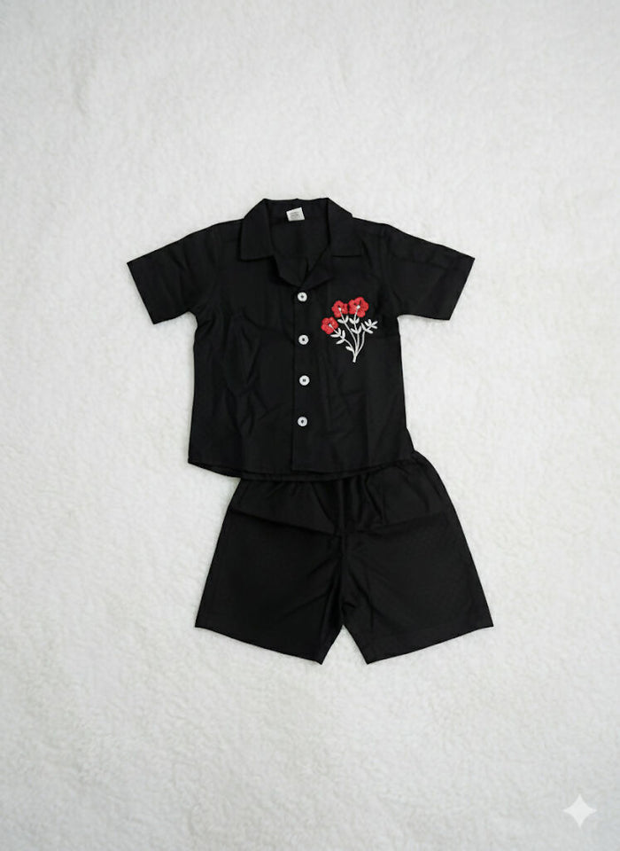 set of black short sleeved shirt and matching black shorts for a child.
