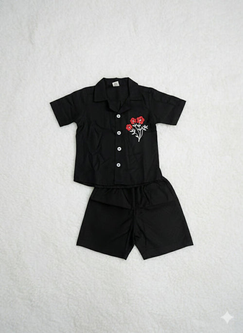 set of black short sleeved shirt and matching black shorts for a child.