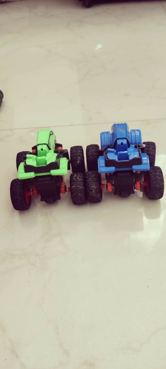 Two toy cars, one green and one blue, on a light-colored floor.