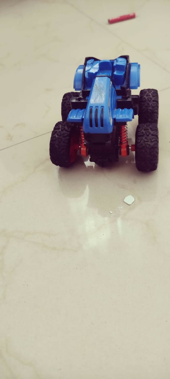 Toy car with blue and black design on a light gray surface