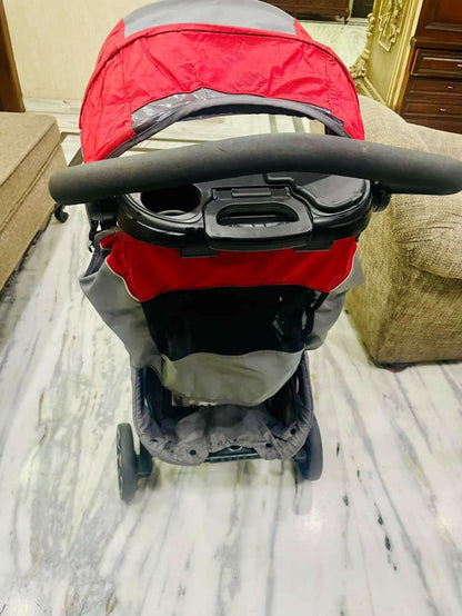 Red and gray stroller on a marble floor