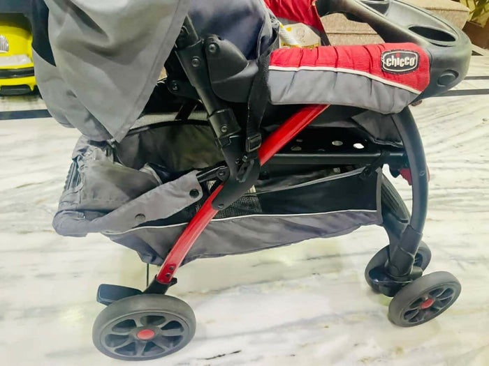 Gray and red stroller with visible brand logo on a light background