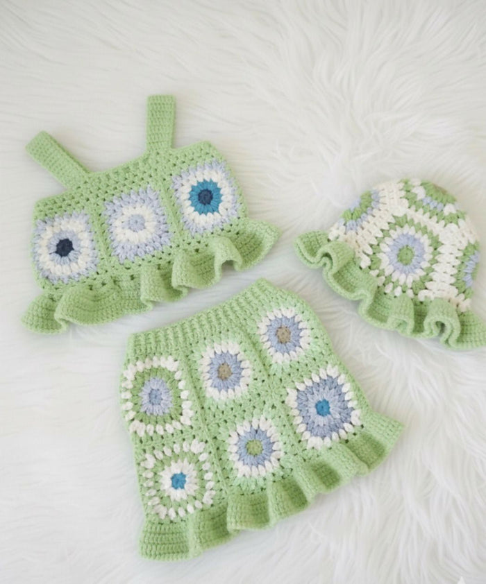 Green crochet baby outfit with floral patterns