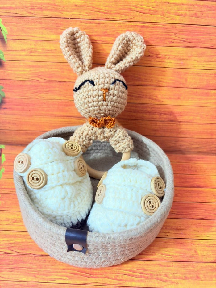 Handmade crochet bunny toy with button details on a wooden surface