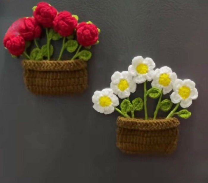 Two crochet flower pots with red flowers and white flowers