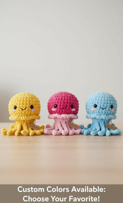 Three colorful crochet jellyfish toys on a wooden surface with a light gray background.