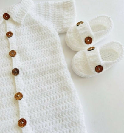 White baby outfit with buttons and white baby shoes