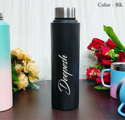 Black water bottle with 'Deepesh' branding on a wooden surface with flowers and other bottles in the background.
