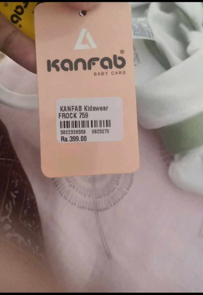 Kanfab baby care tag on a garment with visible text and barcode.