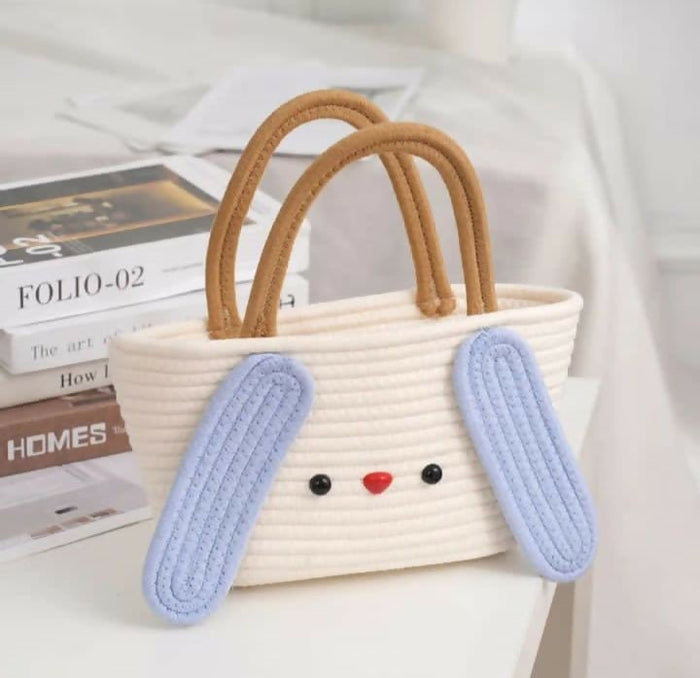 Woven handbag with bunny ears and face on a white surface