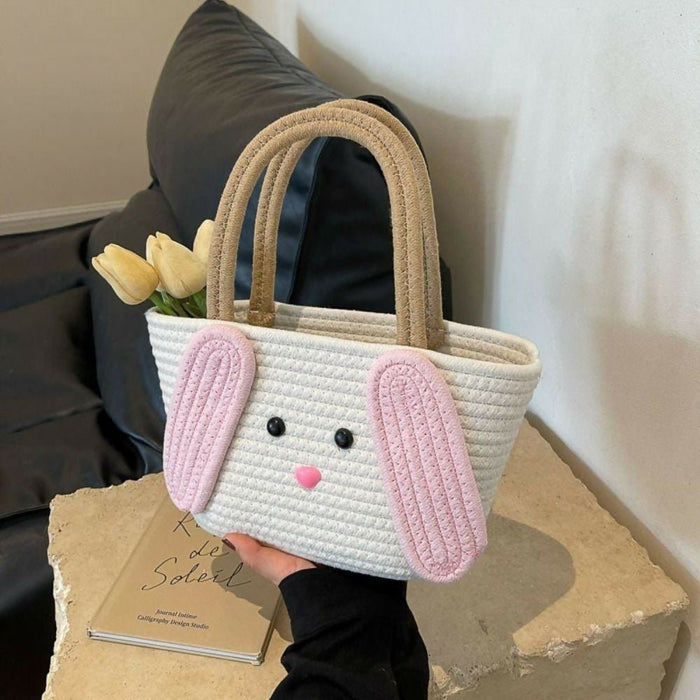 Handheld woven bag with bunny face design on a neutral background