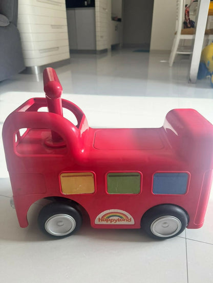 ELC Happyland Ride-On Bus with a colorful bus-inspired design, comfortable seat, sturdy wheels, easy-grip steering handle, and durable construction for fun indoor and outdoor riding play.