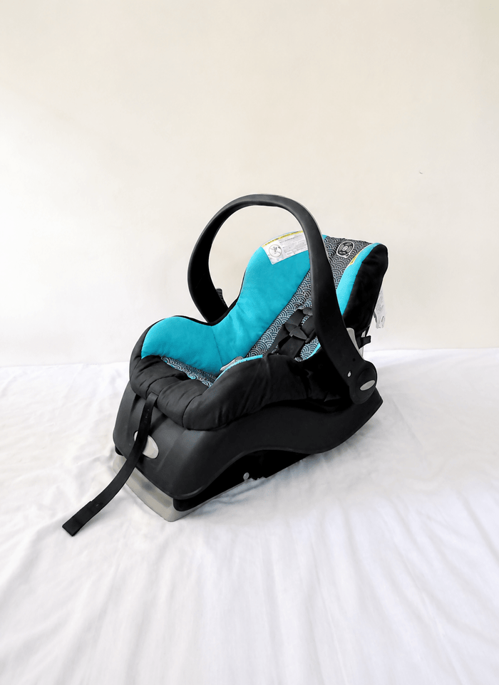 Evenflo Embrace infant car seat with base, rear-facing design, cushioned newborn support, secure safety harness, and portable baby carrier functionality for safe travel.