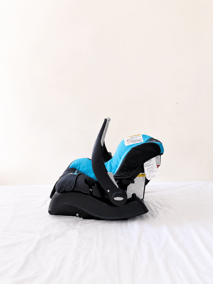 Evenflo Embrace infant car seat with base, rear-facing design, cushioned newborn support, secure safety harness, and portable baby carrier functionality for safe travel.