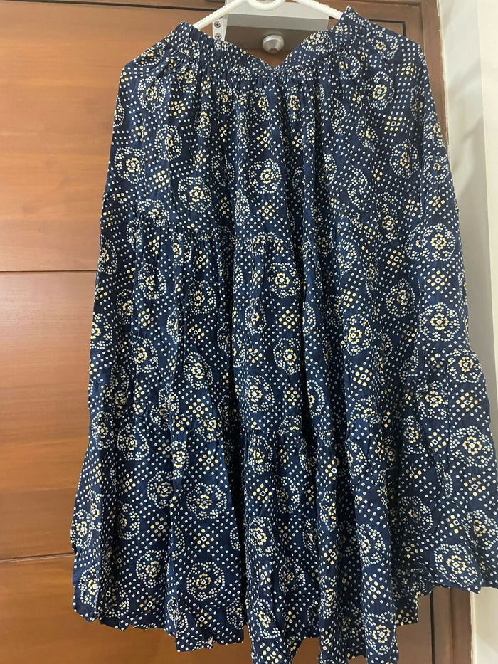 Blue patterned dress on a hanger against a wooden door background