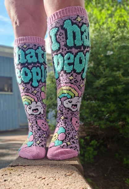 Colorful knee-high socks with text and patterns worn outdoors.