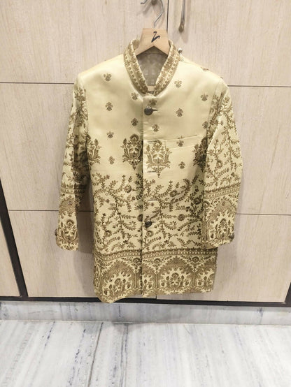 Decorative jacket with intricate patterns on a hanger against a neutral background