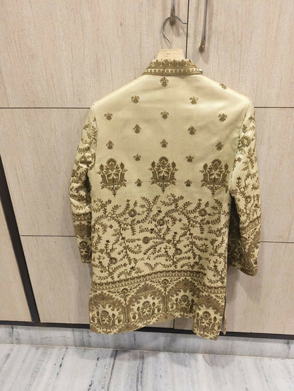 Embroidered traditional jacket on a hanger against a light wooden panel background