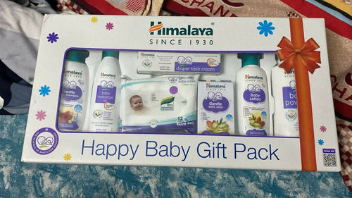 Happy Baby Gift Pack with various baby products on a textured surface