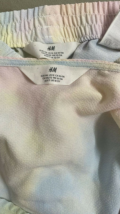 Close-up of an H&M label on a garment with a pastel tie-dye pattern.