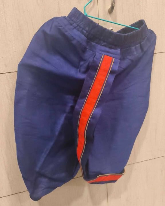 Blue shorts with an orange stripe on a tiled floor
