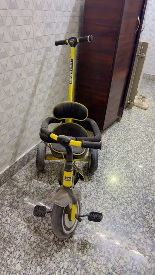 Jam & Honey Baby Tricycle in Almost New condition featuring a sturdy frame, comfortable seat, easy-grip handlebars, smooth wheels, and child-friendly design for fun riding and active outdoor play.