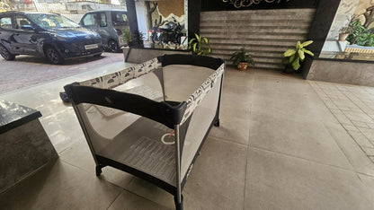 Joie Commuter Change playpen cot with changing station, secure play area, foldable design, mesh sides, and comfortable space for baby sleep, play, and diaper changes.