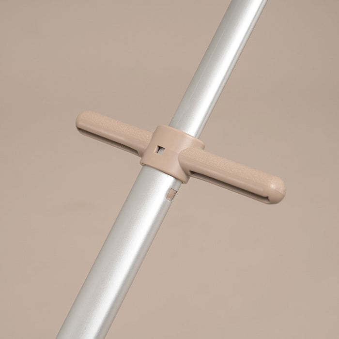 Metal rod with beige crossbar and handles on a beige background