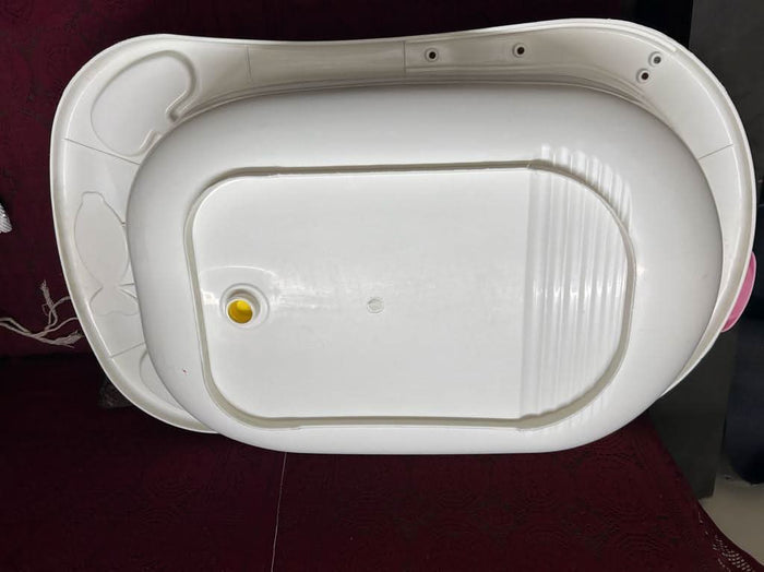 White plastic basin with a yellow dot on a dark surface