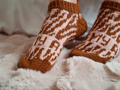 Brown patterned socks on a fluffy white surface