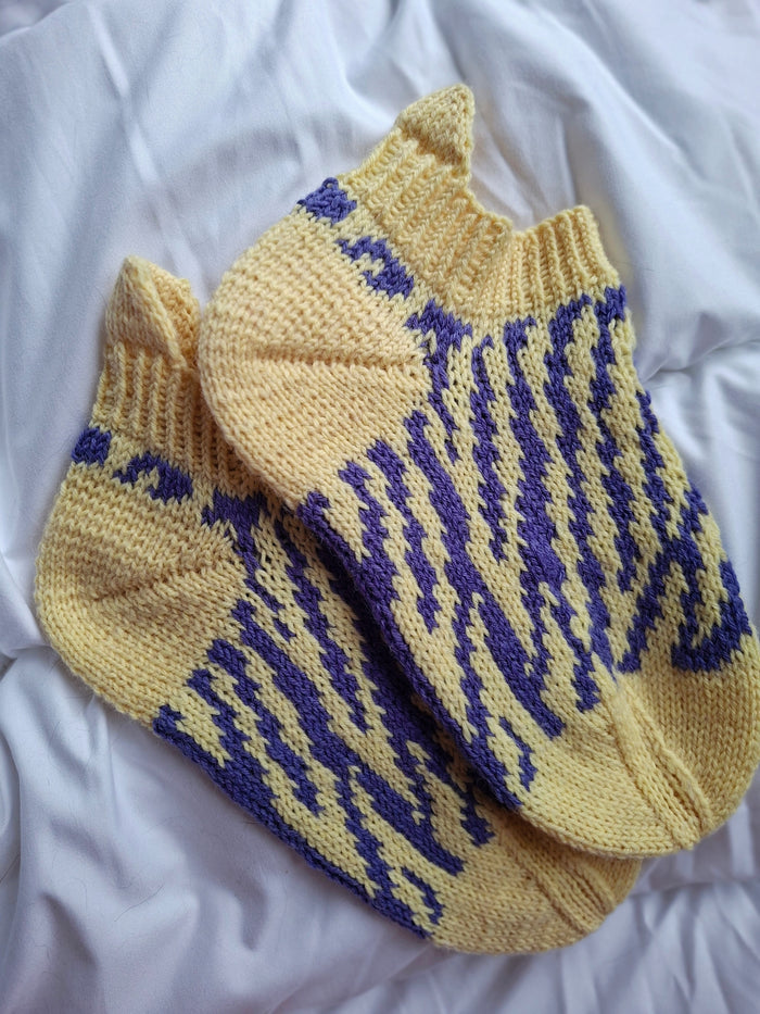 Pair of yellow socks with blue pattern on a white background