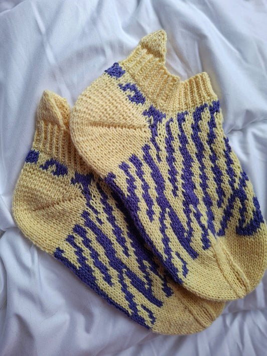 Pair of yellow socks with blue pattern on a white background