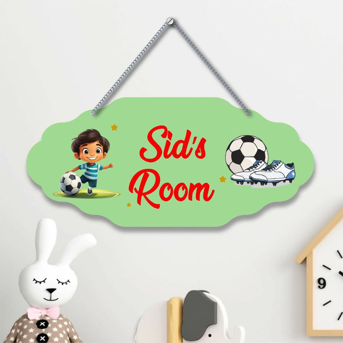 Children's room door sign with cartoon character, soccer ball, and shoes on a light green background.