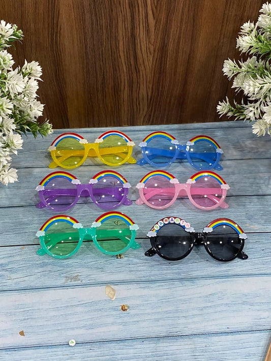 Set of colorful sunglasses with rainbow decorations on a wooden surface.