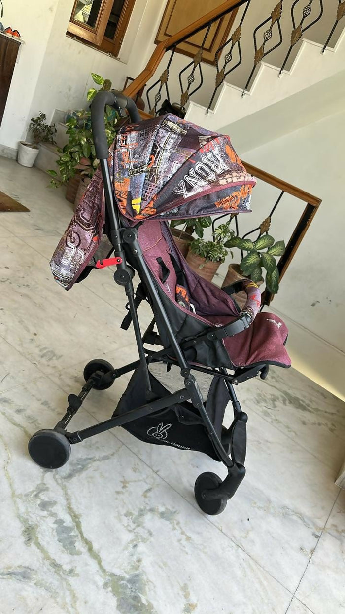 Child's stroller with colorful canopy on a marble floor
