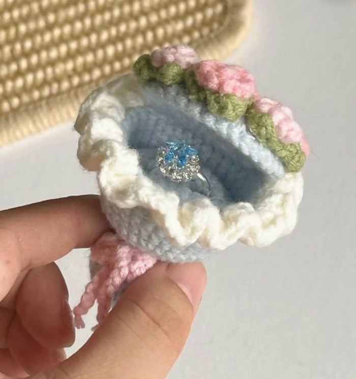 Handmade crochet ring box with flowers held by a hand