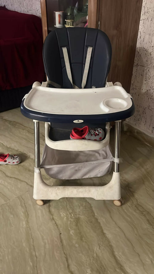 STAR AND DAISY Galaxy Star High Chair with comfortable padded seat, adjustable feeding tray, safety harness, sturdy frame, footrest, and easy-clean design for convenient baby and toddler mealtimes.