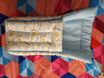 Baby crib with mattress and pillow on a colorful quilted blanket